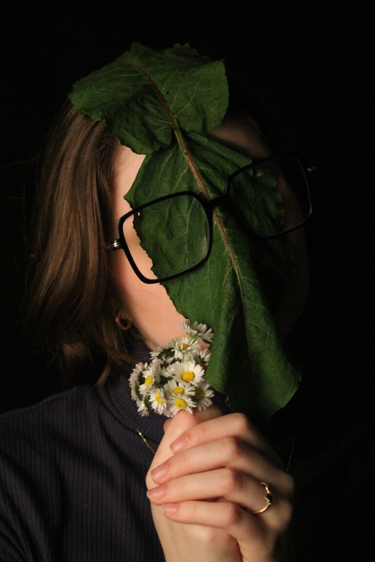 photo d'une fille tenant un bouquet de fleurs, avec une feuille sur la tête
